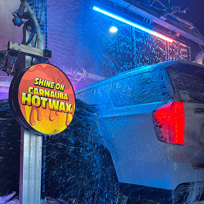 Car wash in tunnel going through hot wax