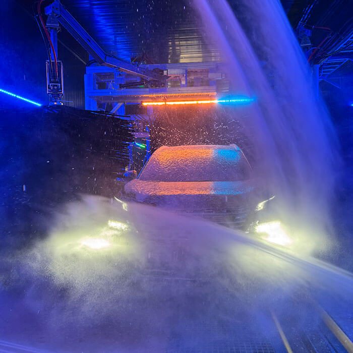 Car getting rinsed inside car wash tunnel