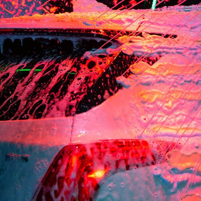 Close up of the back of a car inside the car wash tunnel